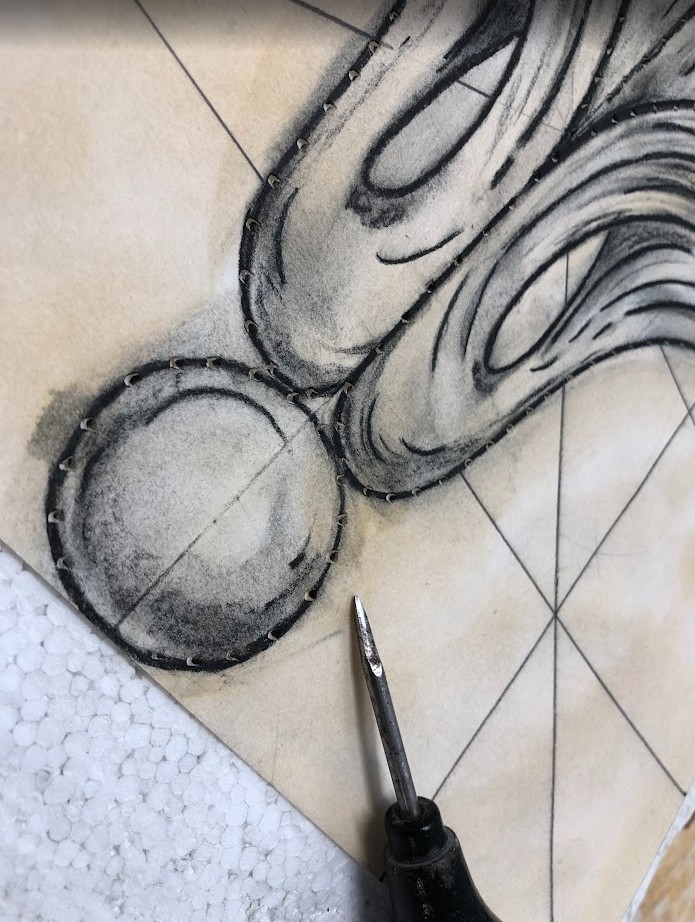 En tegning gjennomhulles langs konturene for å lage en punsetegning. Nærbilde.