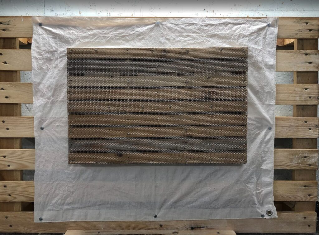 En treramme med lekter og stålnetting for å pusse på. Fra et gipsmakerverksted.