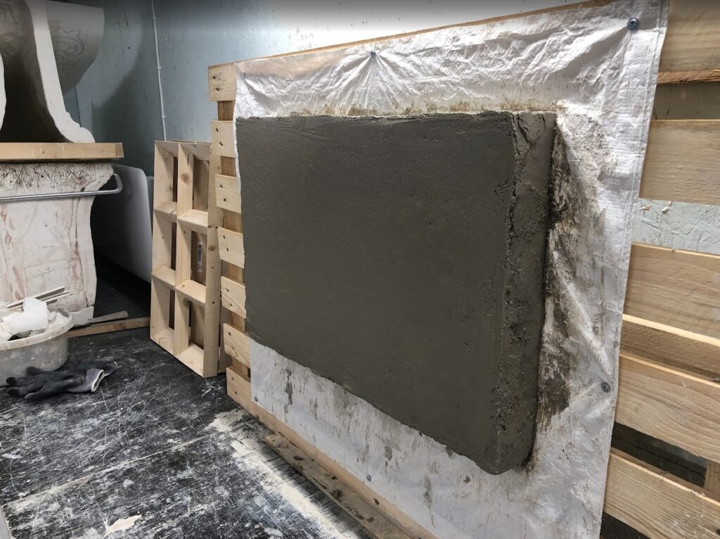 En pusset flate på en treramme med lekter og stålnetting. Fra et gipsmakerverksted.