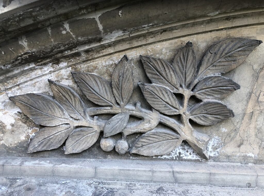 Nærbilde av fasadedekor, et laurbærbladmotiv, på fasaden Parkgata 14 i Ålesund.