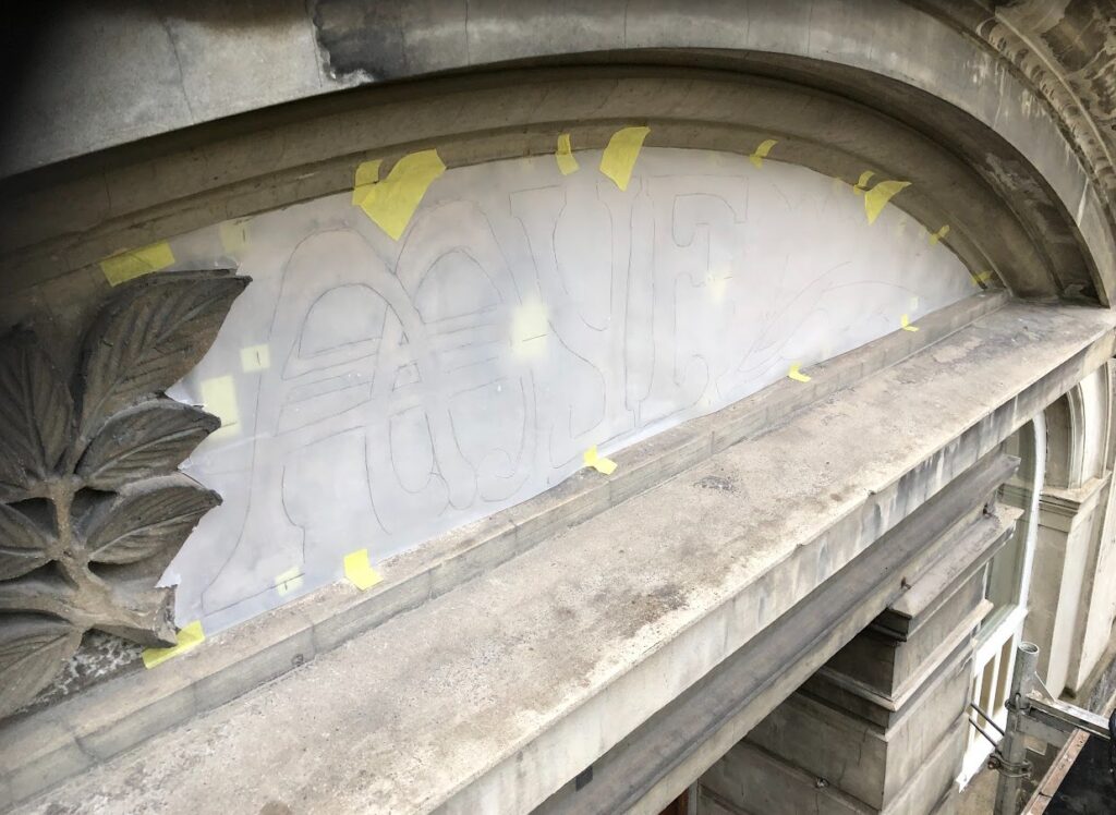 Et fasadeornament tegnes av på fasaden Parkgata 14 i Ålesund.