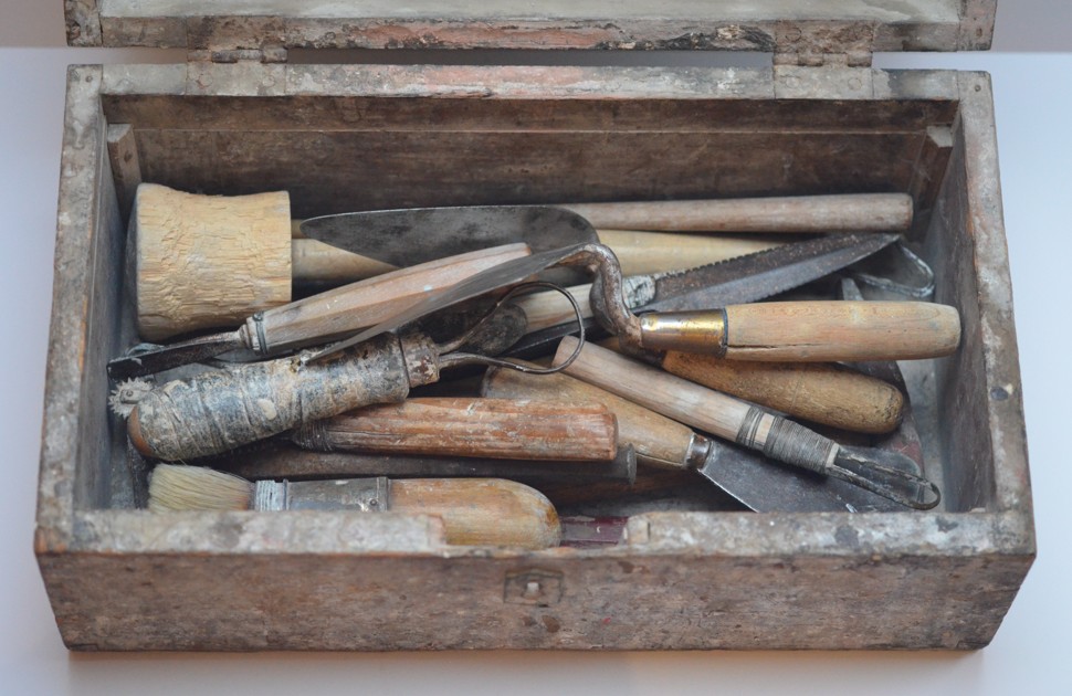 En liten kiste med gamle gipsmakerverktøy i
