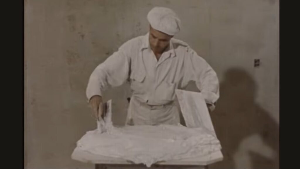 Skjermdump fra filmen Lathing and Plastering fra amerikanske Gypsum Association, trolig fra en gang på 1950- tallet. Her med blanding av finishing plaster.